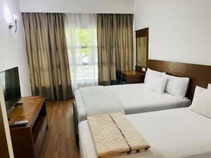 新山EE HOTEL Johor Jaya的酒店客房设有两张床和电视。