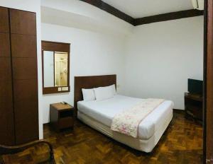 新山EE HOTEL Johor Jaya的卧室配有白色的床和镜子