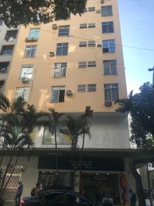里约热内卢Fantástico STUDIO DIVISA COPACABANA IPANEMA REFORMADO E DECORADO的一座高大的建筑,前面有棕榈树