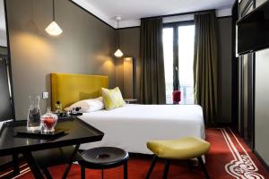 南特L酒店的酒店客房设有一张大床和一张书桌。