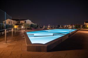 莫尼加派美雅公寓酒店的夜间大型蓝色游泳池