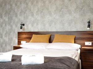 维斯瓦Willa Monte的一间卧室配有带白色床单和黄色枕头的床。