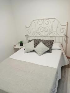 纳维亚Apartamento Ría Navia的卧室配有白色的床和枕头。