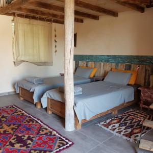 索维拉Slow Luxury at the Serai的一间位于地毯的房间内的卧室,配有两张床