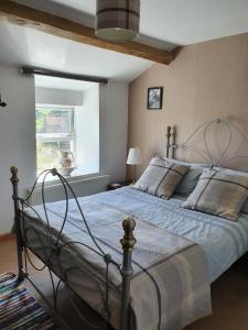 特里迪格Wales' Highest Village - The Chartist Cottage - Trefil的一间卧室配有一张带金属框架的大床
