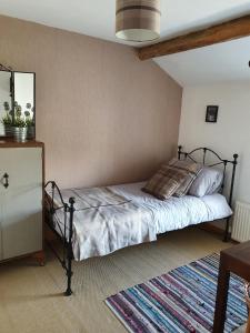 特里迪格Wales' Highest Village - The Chartist Cottage - Trefil的一间卧室配有一张床和一个梳妆台