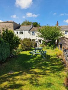 特里迪格Wales' Highest Village - The Chartist Cottage - Trefil的房子前面草上的野餐桌