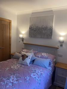 威廉堡Ben Nevis Manor Lodge & Indoor Private Hot-Tub的一间卧室配有一张带枕头的紫色床