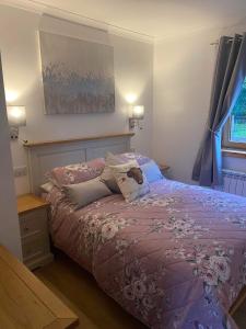 威廉堡Ben Nevis Manor Lodge & Indoor Private Hot-Tub的一间卧室配有一张带紫色棉被的床
