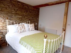 比尔斯韦尔斯Hay Barn, Penrheol Farm, Unique Barn Conversion的卧室配有白色的床铺和石墙