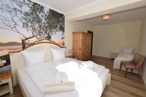 BosauLandhaus Hideaway mit Aussenpool, Sauna und Kamin的卧室配有一张白色床,墙上挂有绘画作品