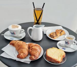 索伦托RossHouse的一张桌子,上面放着羊角面包、咖啡和面包