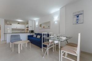 洛斯克里斯蒂亚诺斯LosCristianos Front Line of Ocean WiFi的客厅配有桌子和蓝色沙发
