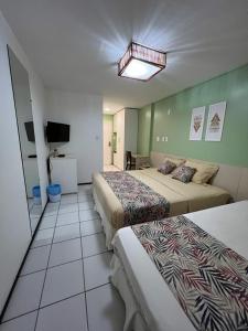 巴雷里尼亚斯Gran Lençois Flat Residence - Barrerinhas (Aptº Particular)的酒店客房设有三张床和电视。