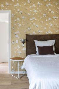 AlveringemB&B Leonie的一间卧室配有一张带花卉图案墙壁的床