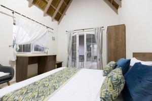 瓦杜Laguna Vadu的一间卧室配有一张床、一张书桌和一个窗户。