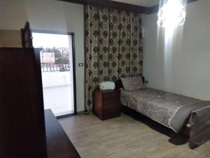 马达巴City Center Furnished Apartment的一间卧室设有一张床和一个滑动玻璃门