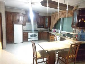 马达巴City Center Furnished Apartment的厨房配有木制橱柜和桌椅