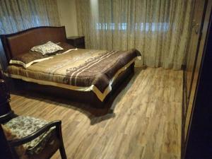 马达巴City Center Furnished Apartment的一间卧室配有一张床,铺有木地板