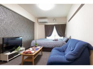 京都cozy house - Vacation STAY 13159的客厅配有蓝色的沙发和床。