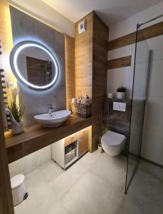 波兹南Malta Delux Apartment, free parking, self check-in 24h的一间带水槽和镜子的浴室
