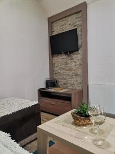 科帕奥尼克Vikendica Čeperković #2的一间客厅,客厅内配有桌子和砖墙上的电视