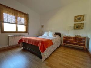里瓦达维亚ENTRETOXOS的一间卧室配有一张床、一个梳妆台和一扇窗户。
