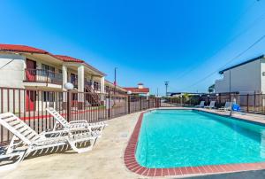 梅斯基特Red Roof Inn Dallas - Mesquite Fair Park NE的一个带2把躺椅的游泳池和一个游泳池