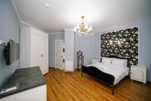 第比利斯Rose Hotel & Hostel Vake的一间卧室配有一张床和一个吊灯