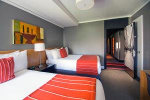 西雅图麦克斯酒店的一间酒店客房,设有两张床和走廊