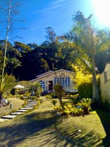 彼得罗波利斯Pousada Valparaiso的前面有棕榈树的房子
