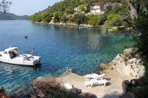 UbliApartments by the sea Ubli, Lastovo - 8354的船上的船只停靠在湖上,配有桌椅