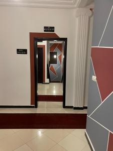 科托努HOTEL LES ARCADES的大楼内带镜子的走廊