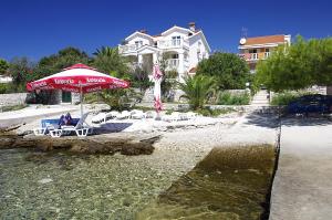 尼亚卢卡Apartments by the sea Cove Gradina, Korcula - 9273的海滩上的一组椅子和一把遮阳伞