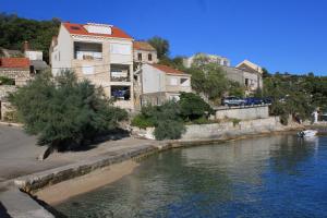 拉茨斯切Apartments by the sea Racisce, Korcula - 9337的河边的建筑物,有房子