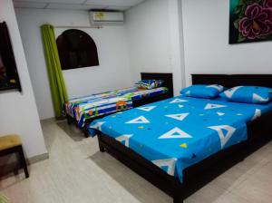 库库塔阿库阿里乌斯酒店的一间卧室配有两张蓝色床单