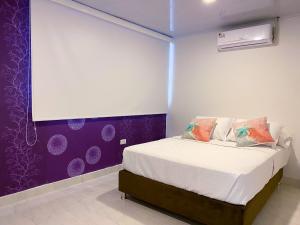 圣安德烈斯OCEANA HOTEL的一间卧室配有一张紫色墙壁的床
