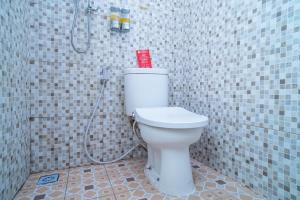 贝努阿亚尔RedDoorz Syariah near Taman Siring 2的浴室设有带淋浴的白色卫生间。