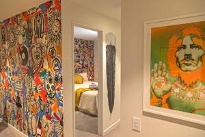 基督城Funk in the City - Luxury Laneway Apartment的墙上装饰着色彩缤纷的绘画的房间