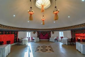 博孔巴耶沃Yurt camp Meiman Ordo的宴会厅配有桌椅和吊灯