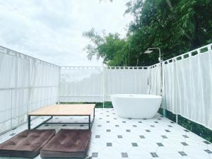 清莱La Maison Blanche Chiang Rai Resort的浴缸位于带桌子的庭院