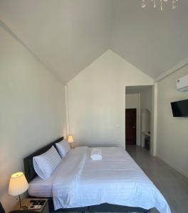 清莱La Maison Blanche Chiang Rai Resort的一间卧室配有一张带白色床单的大床