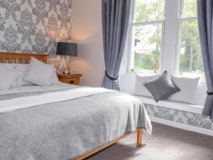 温德米尔Oldfield House的一间卧室设有一张床和两个窗户。