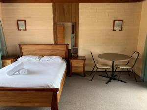 伯马吉雷加特角假日公园的卧室配有一张床和一张桌子及椅子
