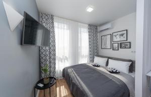 基辅MYFREEDOM Апартаменти метро Нивки的一间卧室配有一张床和一台平面电视