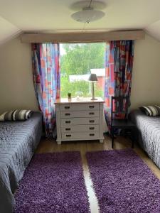 库奥皮奥Cottage Elsa的一间卧室设有两张床和一个带窗户的梳妆台。
