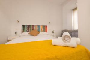 格拉纳达Apartamento Ribera del Genil Centro的一间卧室配有一张带黄色毯子的大床