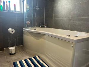 伦敦Deluxe Homestay near Tottenham Hotspur Stadium的带浴缸和盥洗盆的浴室