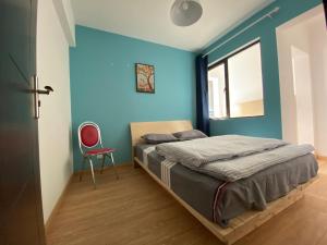昆明合家欢的一间拥有蓝色墙壁的卧室和一张带红色椅子的床