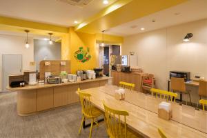 札幌Hotel Axia Inn Sapporo Susukino的餐厅设有黄色椅子和长桌
